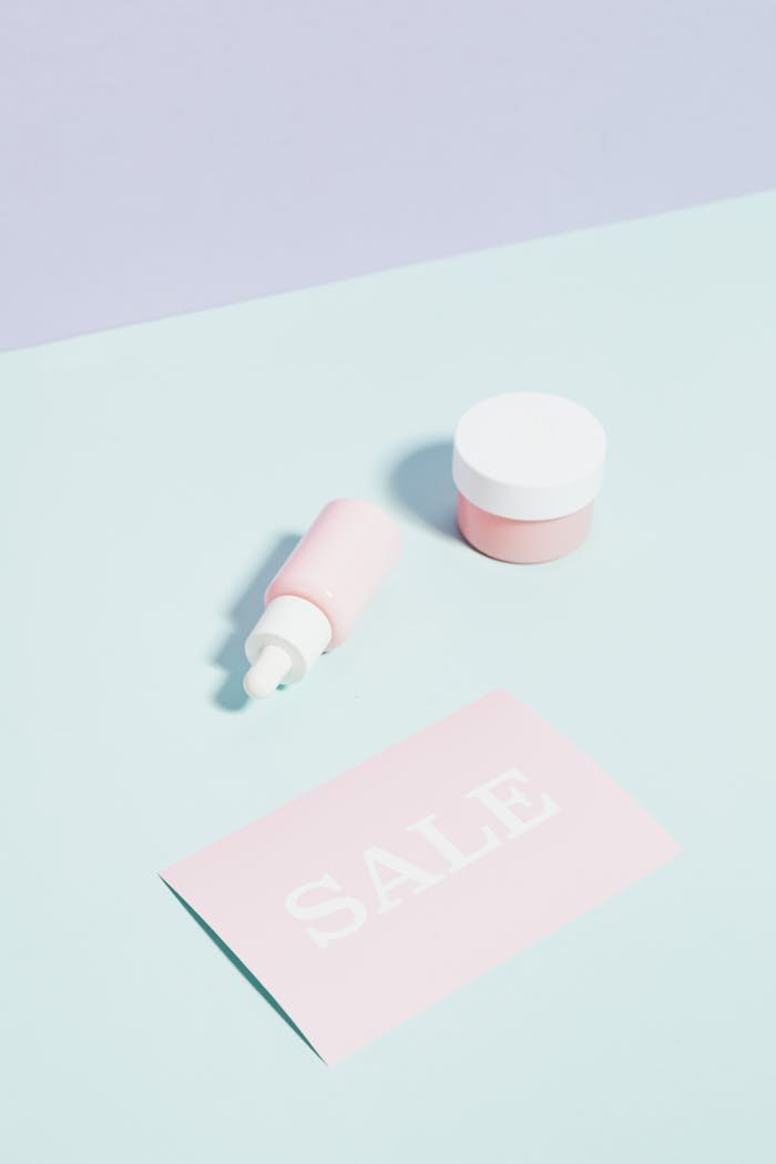 Flat lay of skincare products with a sale card in pastel colors for beauty promotions.